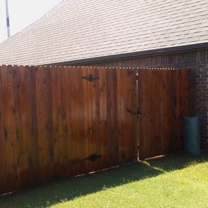 A wooden fence is in front of a brick building