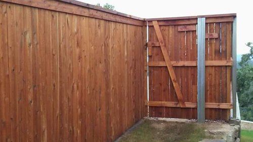 A wooden fence with a gate in the middle of it.