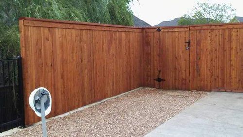 A wooden fence with a gate in the backyard.
