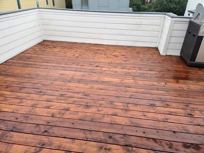 A wooden deck with a grill on the side of it.