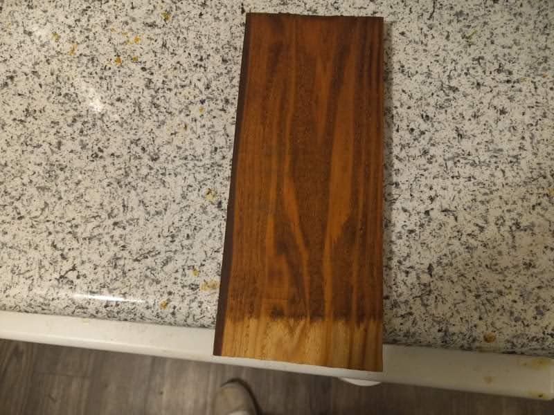 A piece of wood is sitting on top of a granite counter.