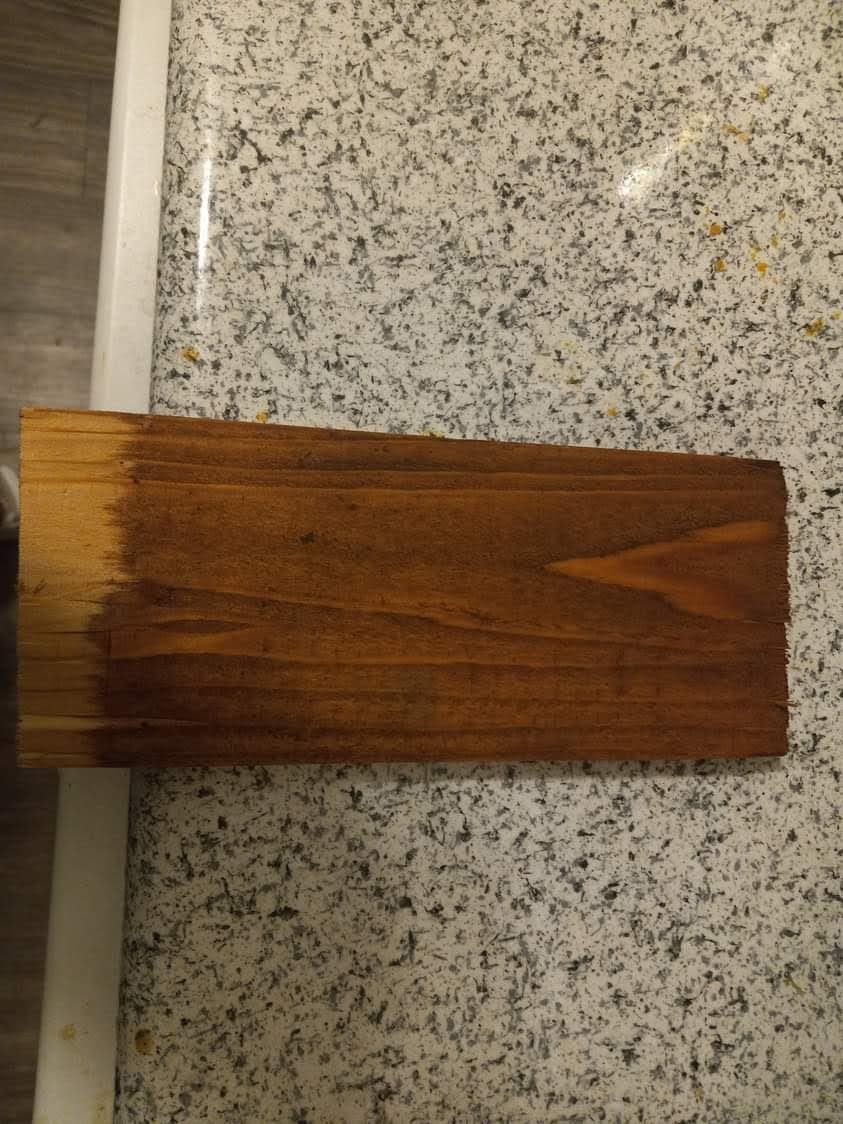 A piece of wood is sitting on top of a granite counter.