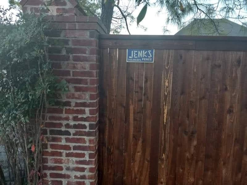 A wooden fence with a sign on it that says jenks