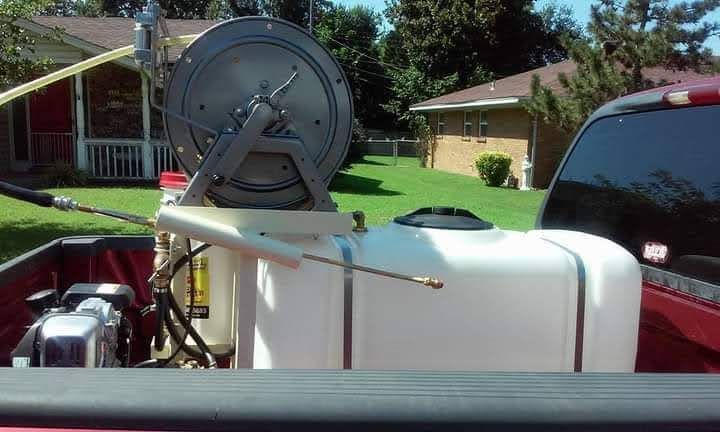 A red truck with a hose reel attached to the back of it