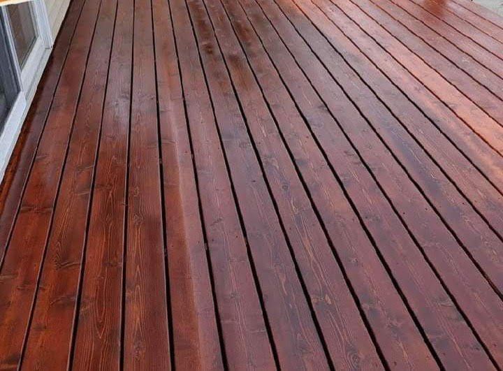 A close up of a wooden deck with a white building in the background