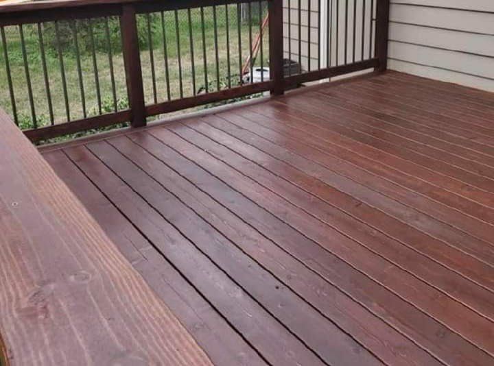A wooden deck with a metal railing and a bench.