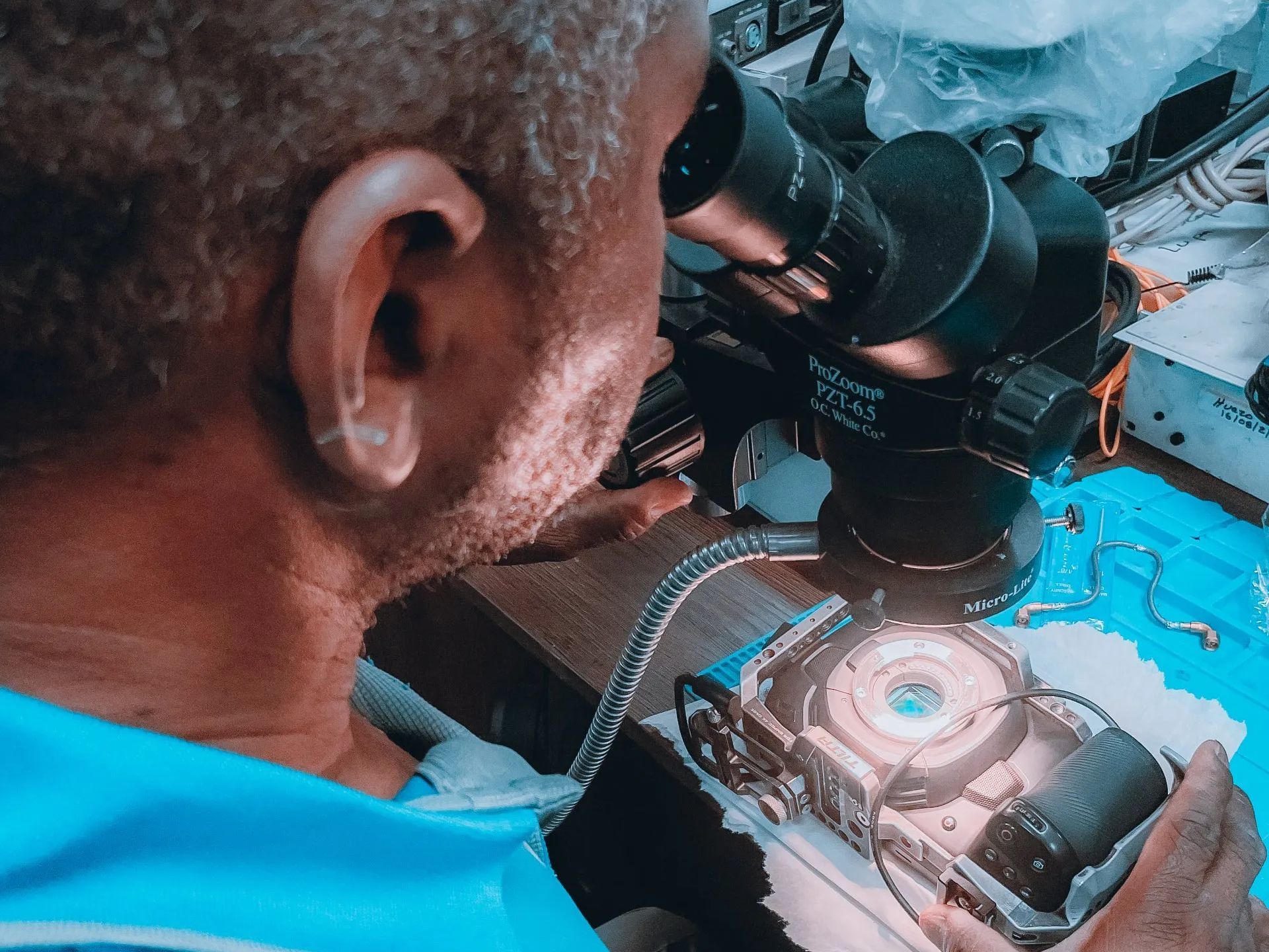 a man is working on a camera under a microscope .