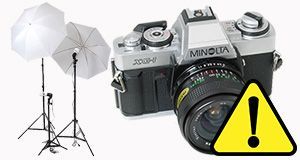 a camera with a yellow warning sign next to it .