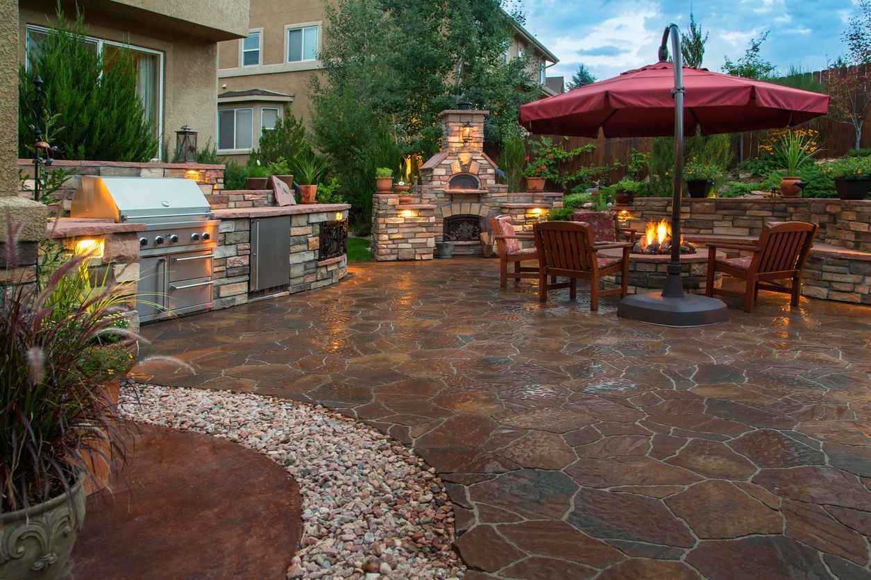 Patio featuring an outdoor kitchen made from different stones - using hardscape solutions for landscaping.