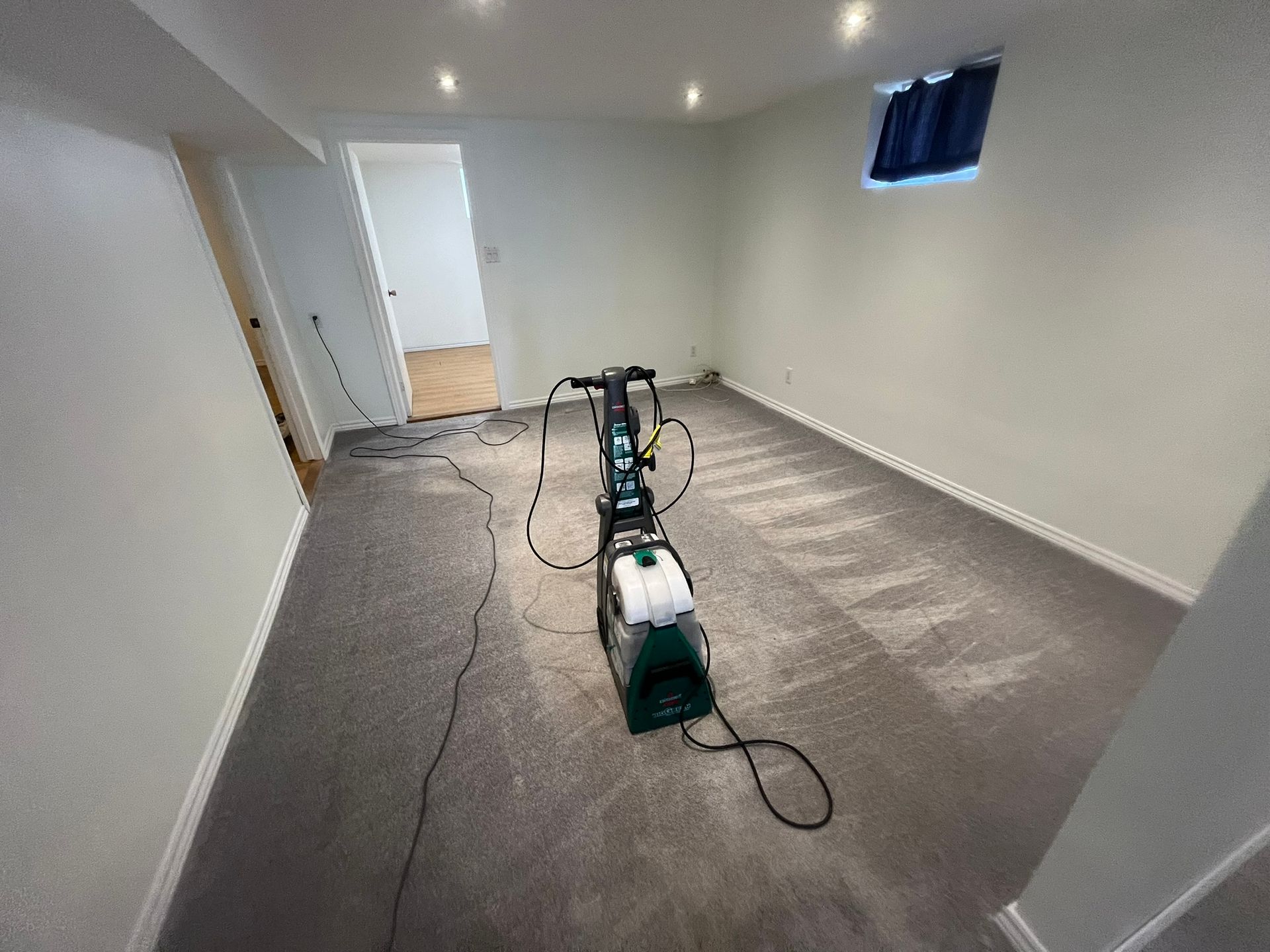 An empty room with a vacuum cleaner on the floor.
