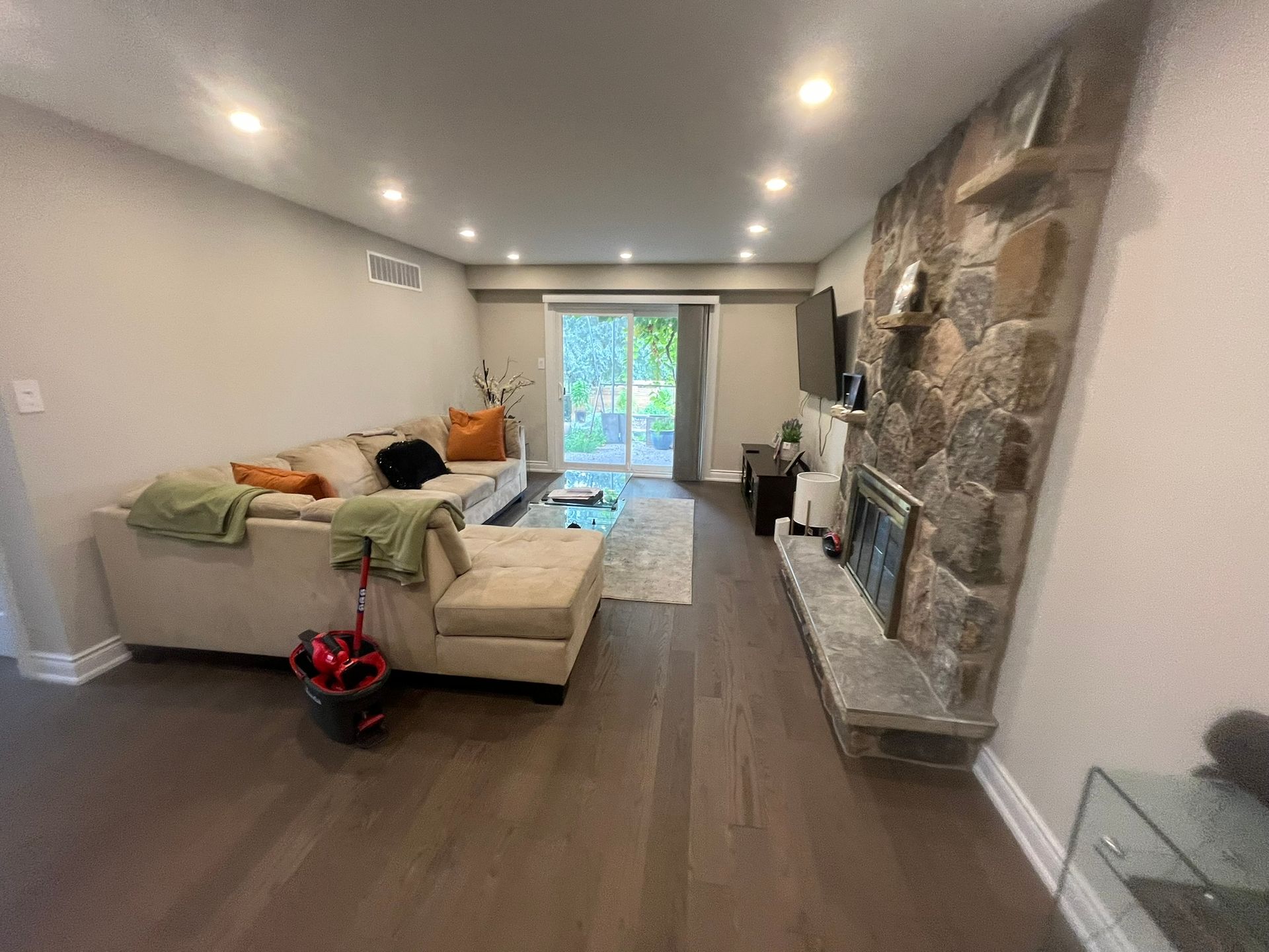 A living room with a couch , fireplace and sliding glass doors.