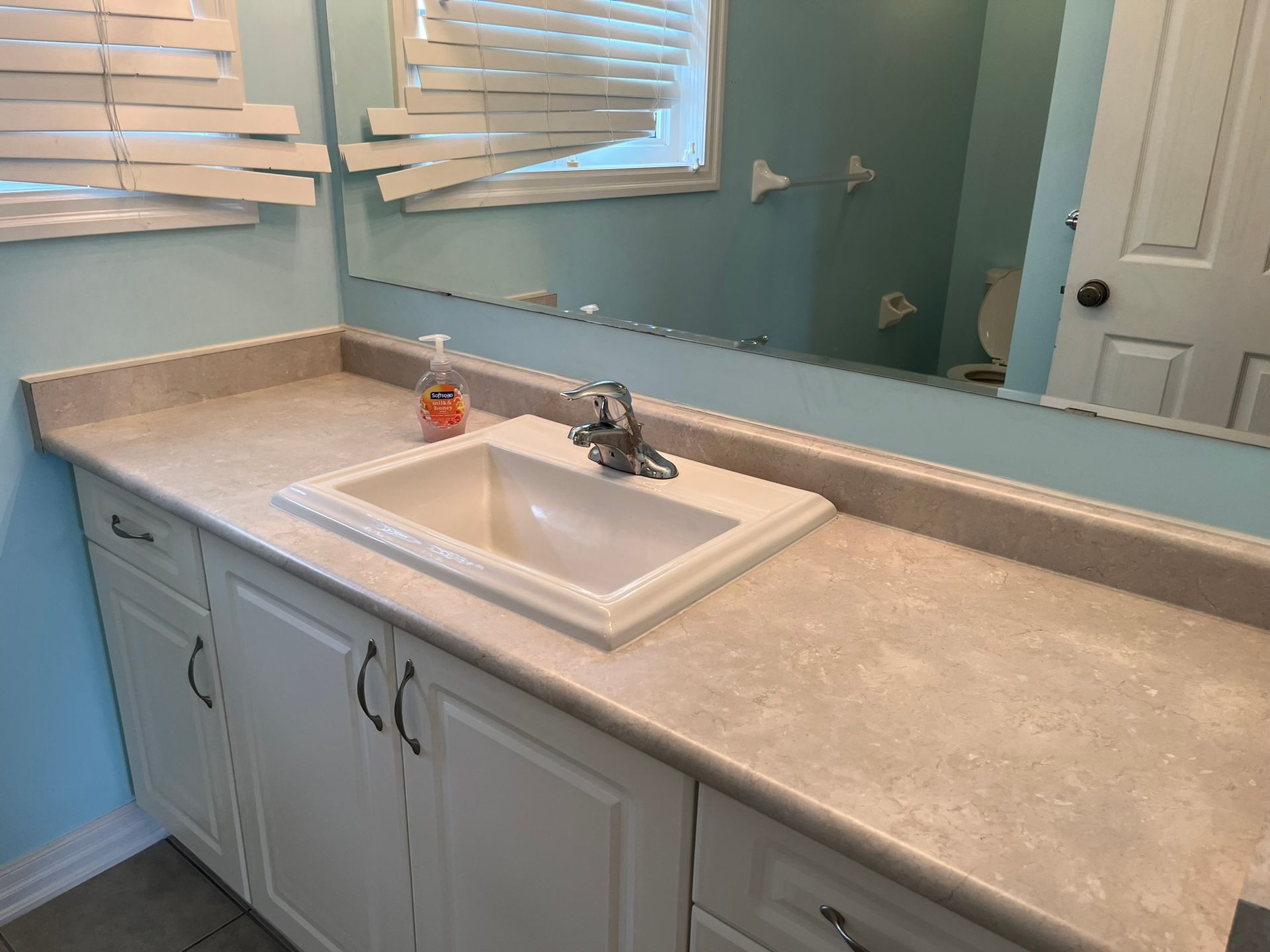 A bathroom with a sink and a mirror.