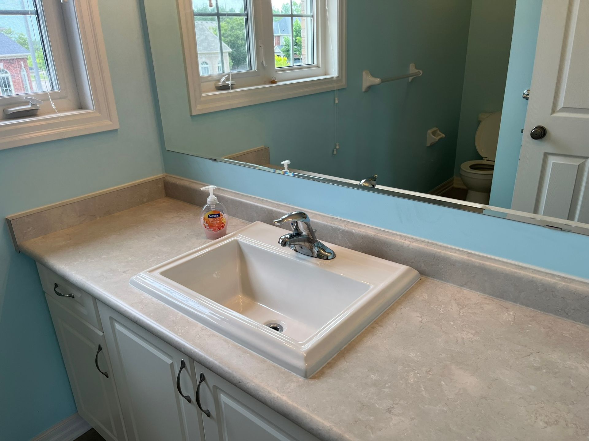 A bathroom with a sink and a large mirror