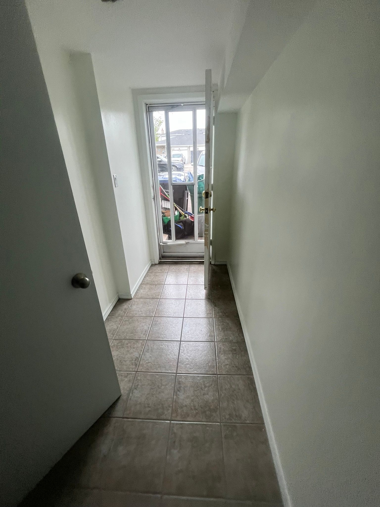 A long hallway with a sliding glass door leading to a balcony.