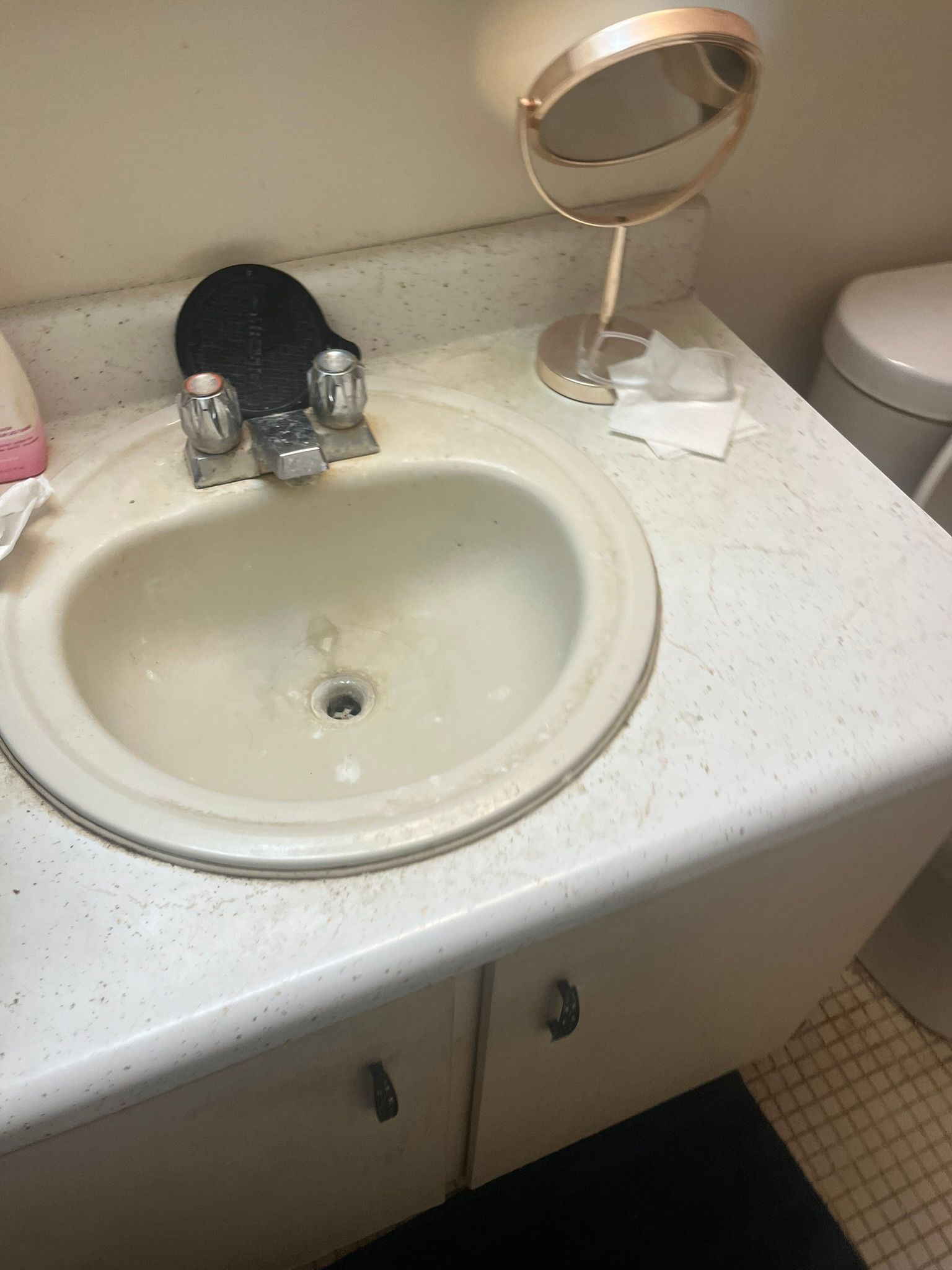 A bathroom sink with a mirror and a toilet.