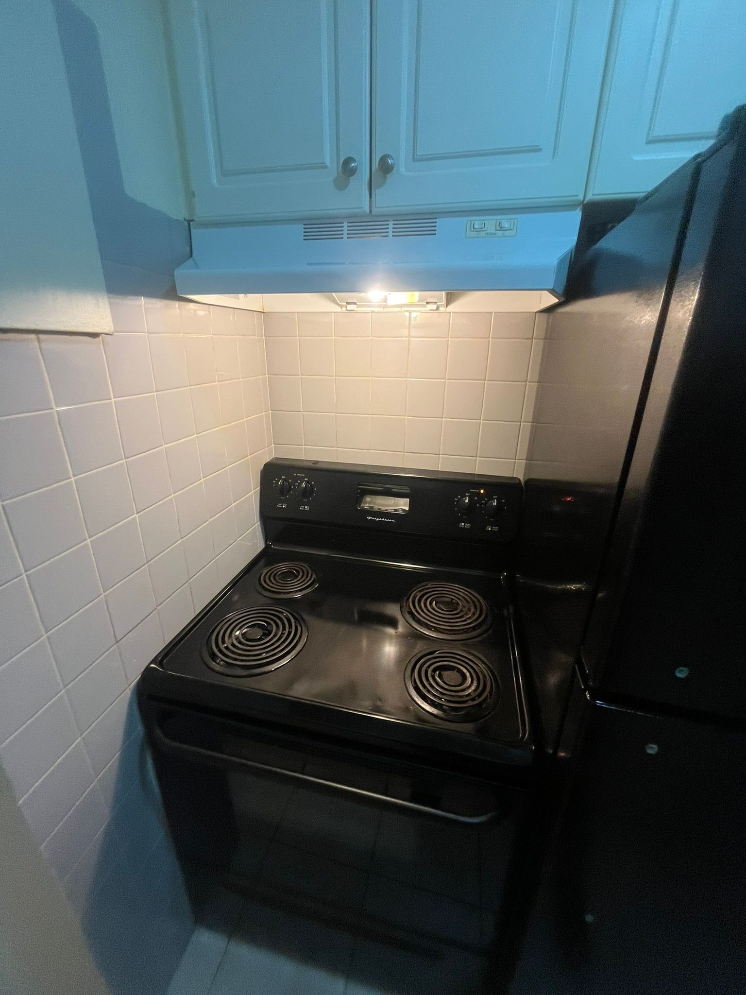 A black stove top oven with four burners is in a kitchen.