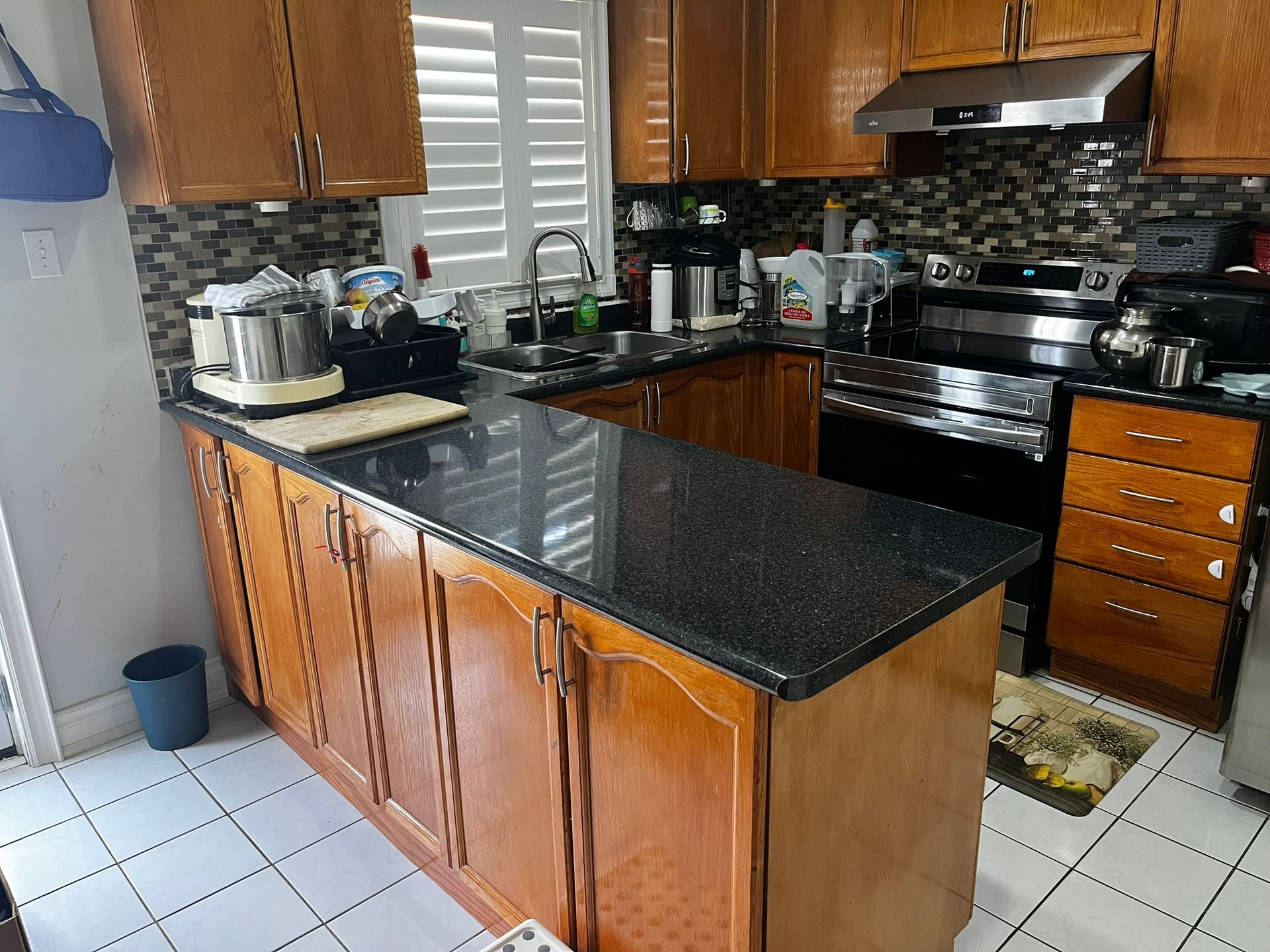 A kitchen with wooden cabinets and black granite counter tops