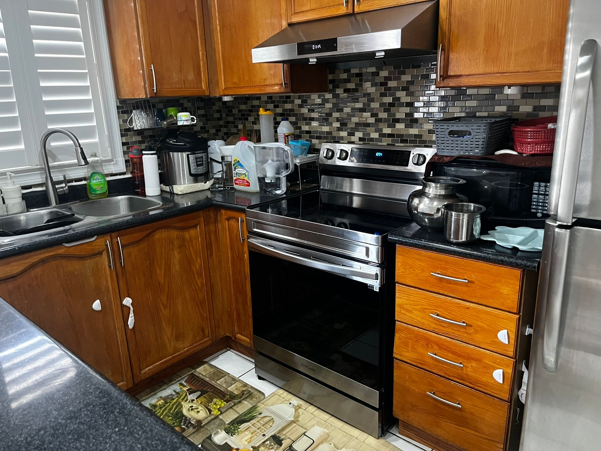 A stainless steel oven is sitting on a wooden floor.