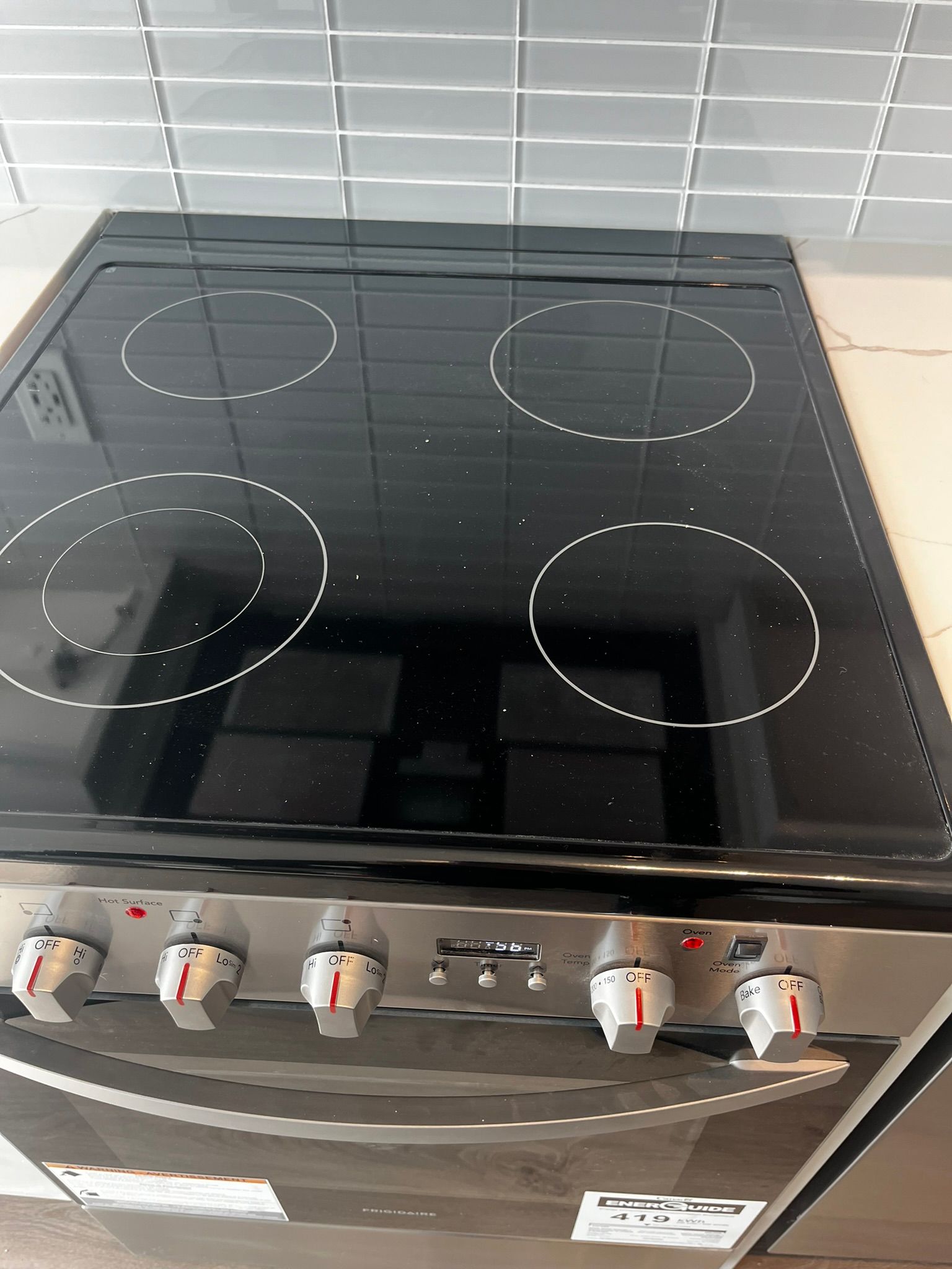 A stainless steel kitchen sink with a black faucet.