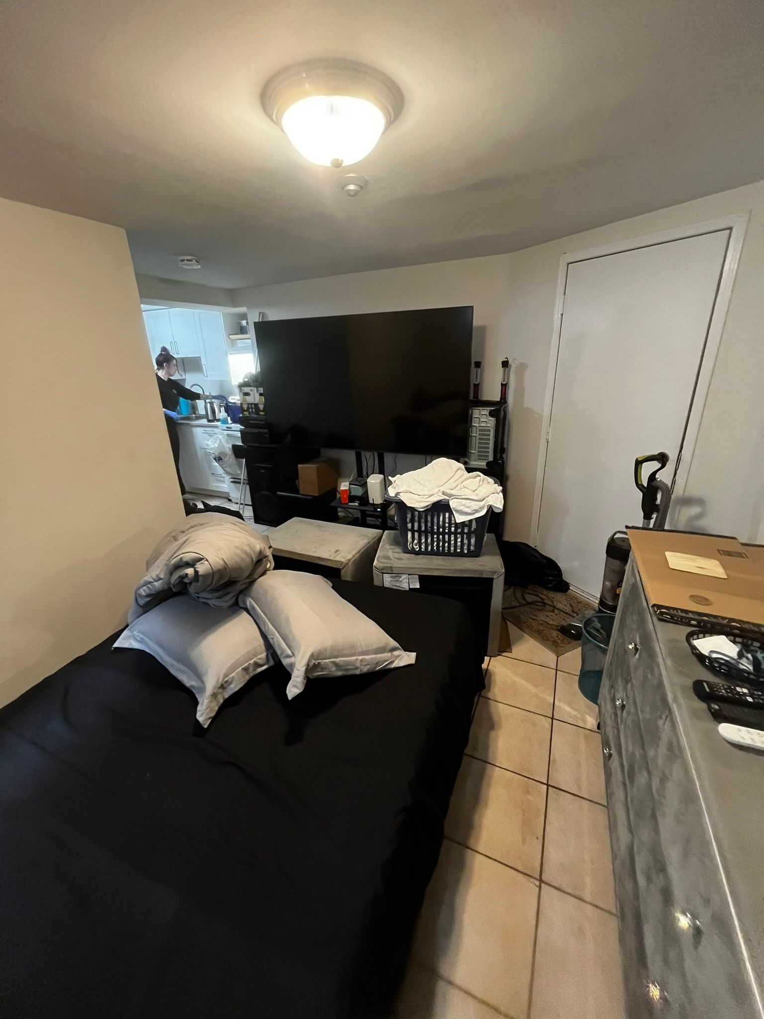 A bedroom with a bed , television , and a dresser.