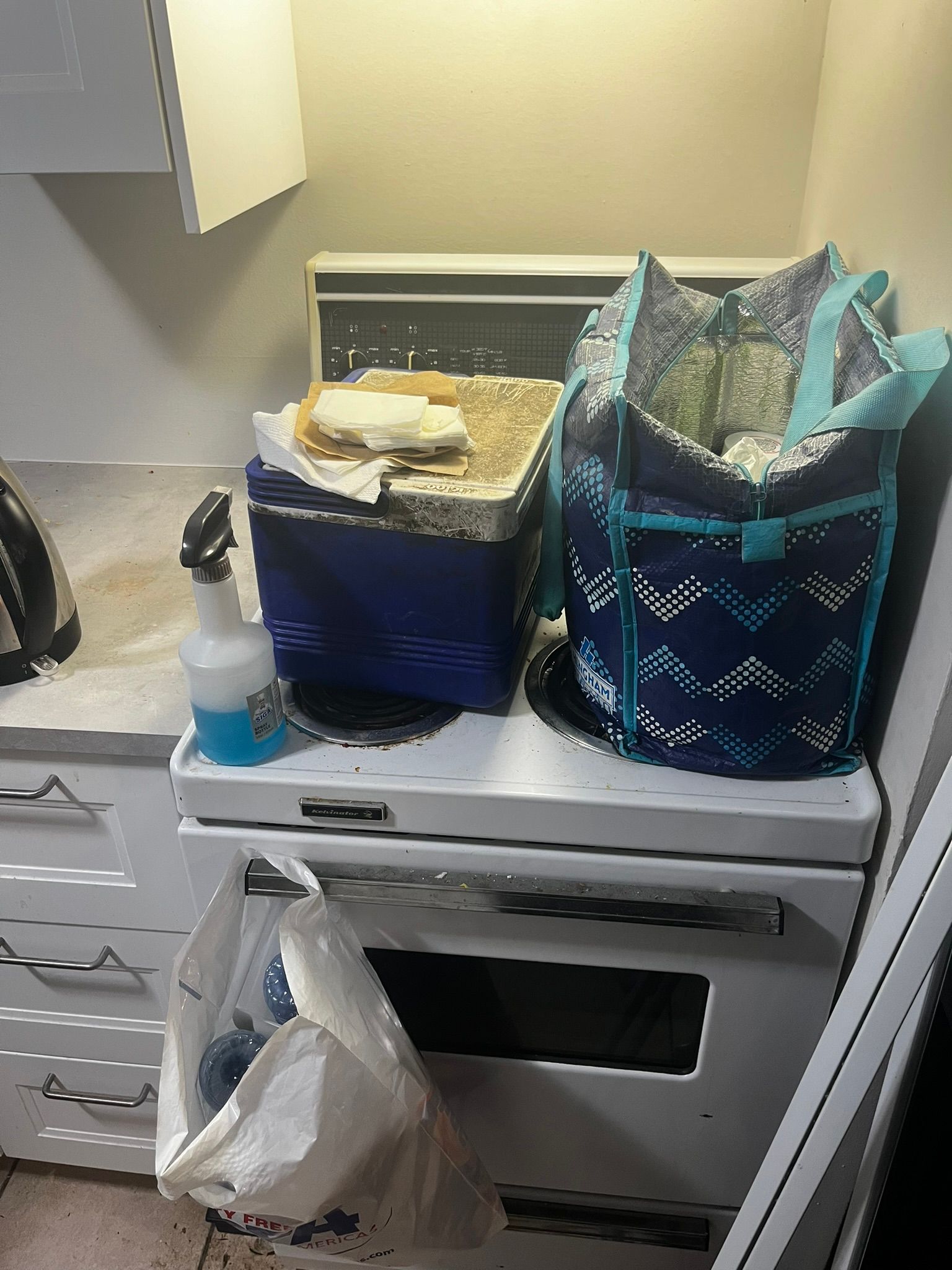 A kitchen with a stove and a bag on top of it.