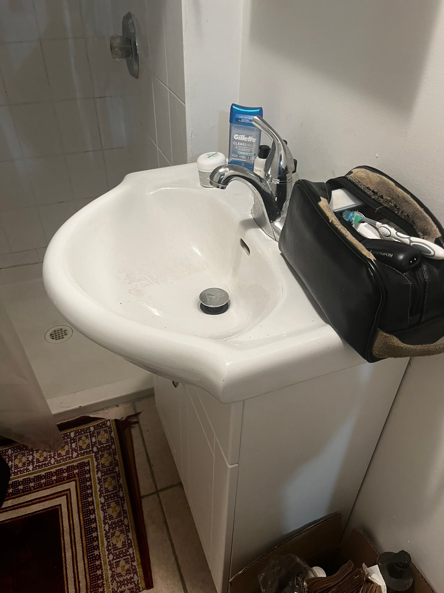 A bathroom with a toilet , sink , and shower.
