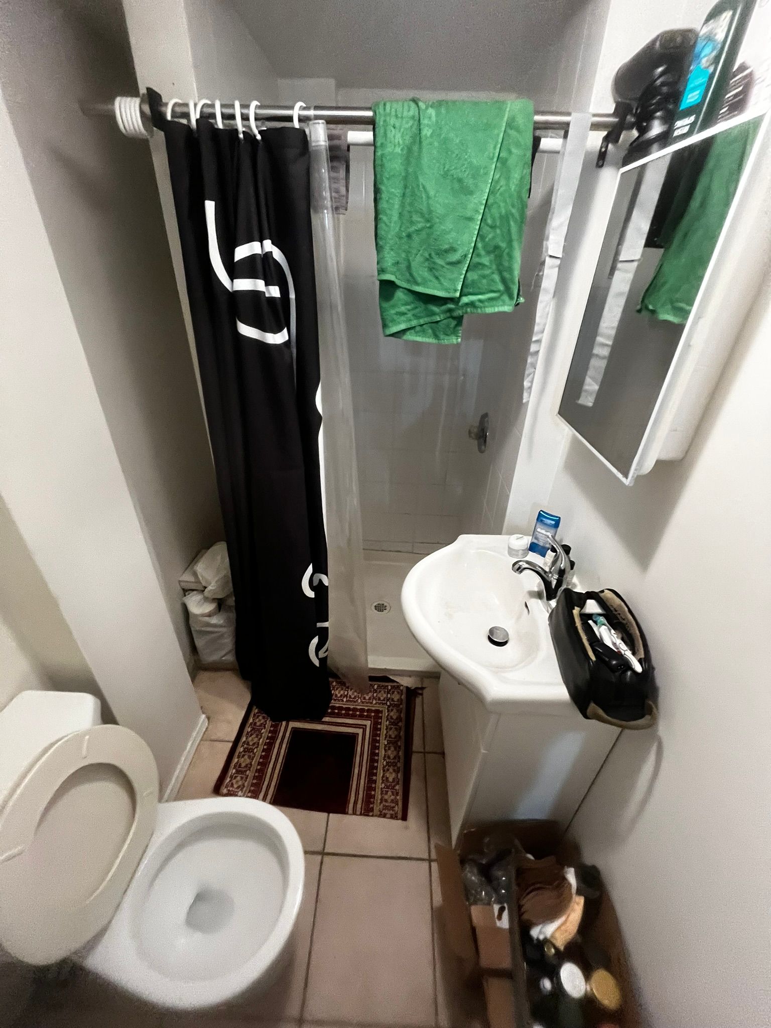 A bathroom with a toilet , sink , and shower.