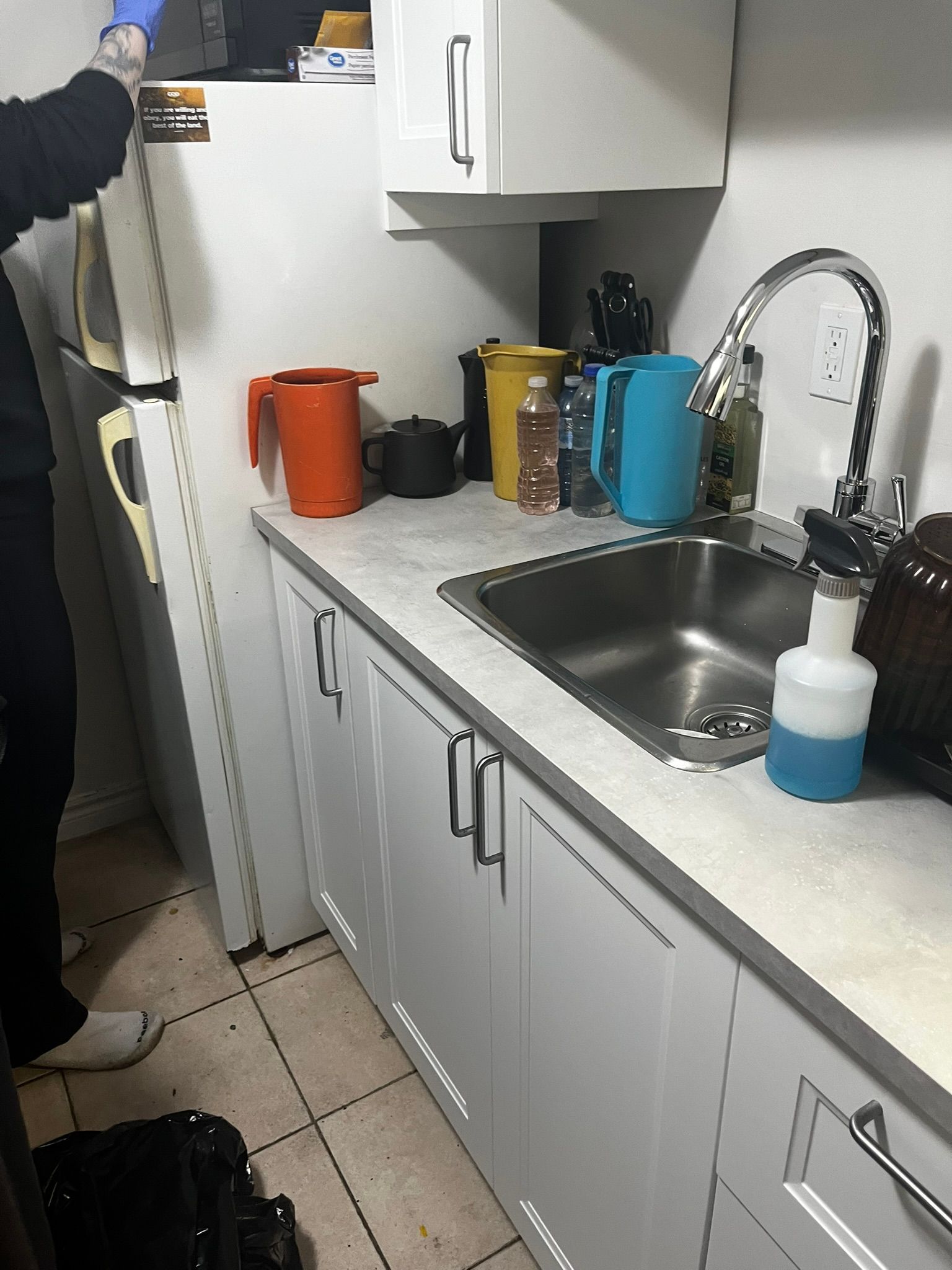 A kitchen with white cabinets and a sink