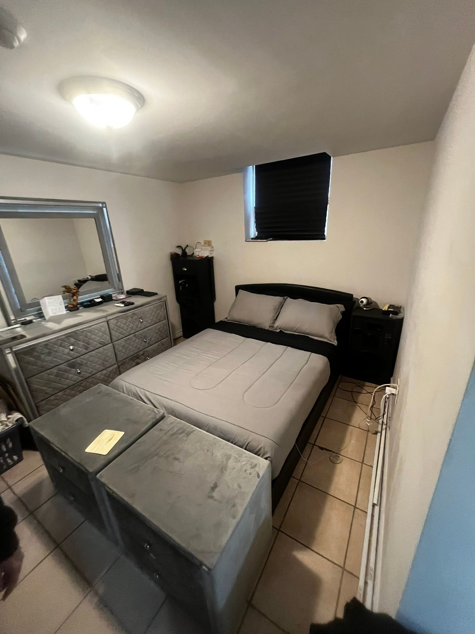 A bedroom with a bed , dresser , mirror and nightstands.