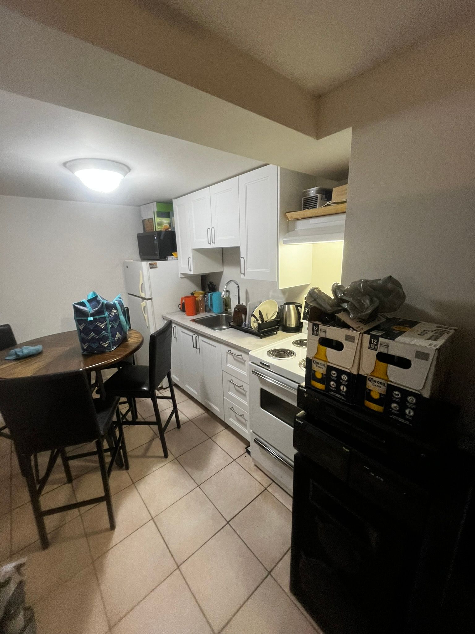 A kitchen with a table and chairs and a refrigerator.