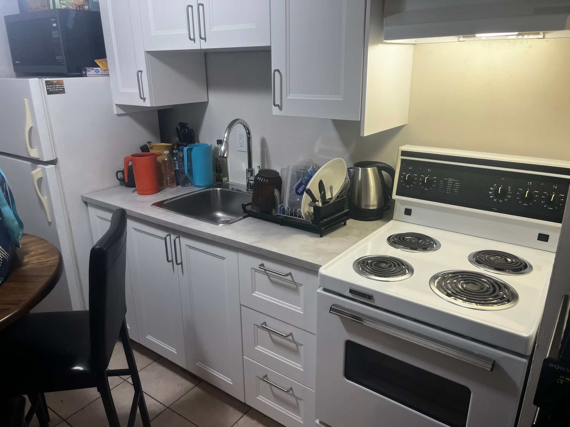 A kitchen with a stove , sink , and refrigerator