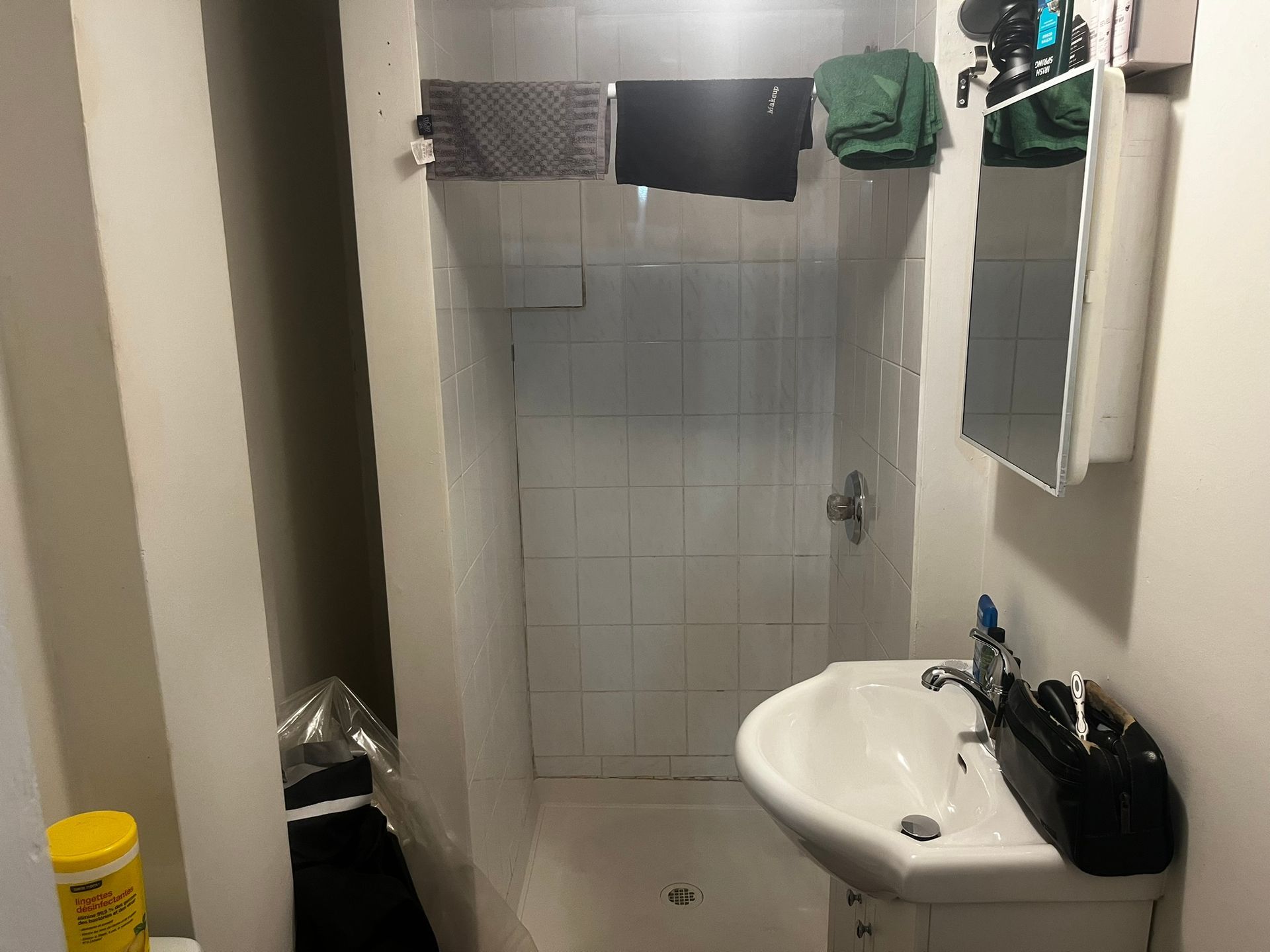 A bathroom with a sink , mirror and shower.