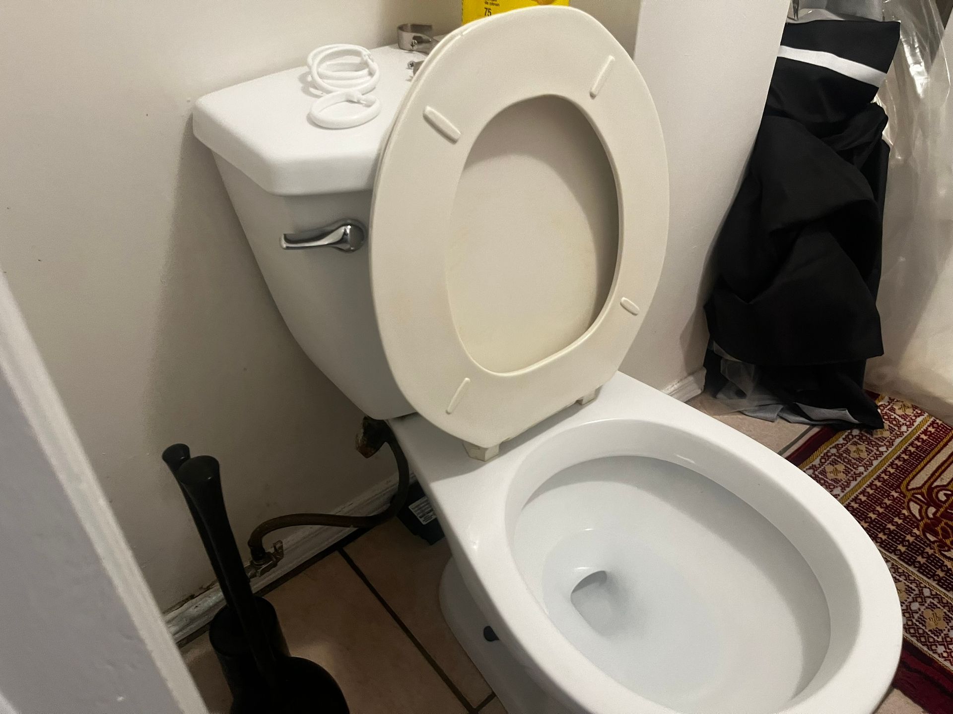 A toilet with the lid up in a bathroom