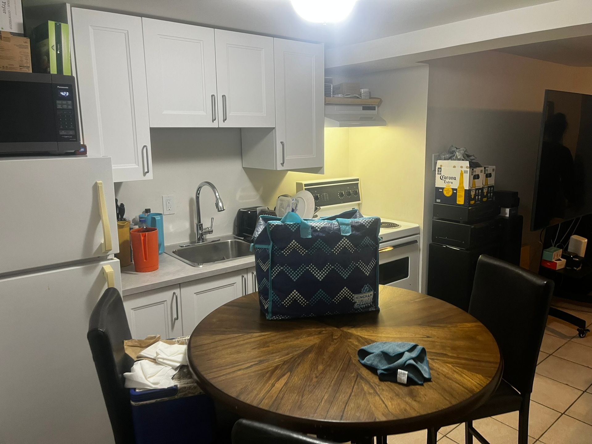 A kitchen with a round table and chairs and a bag on the table