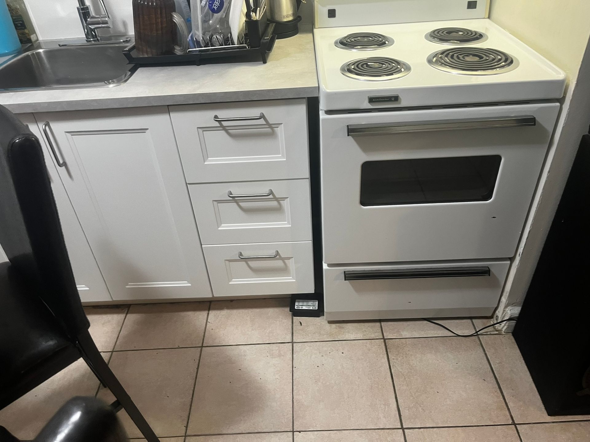 A kitchen with a stove top oven and a sink