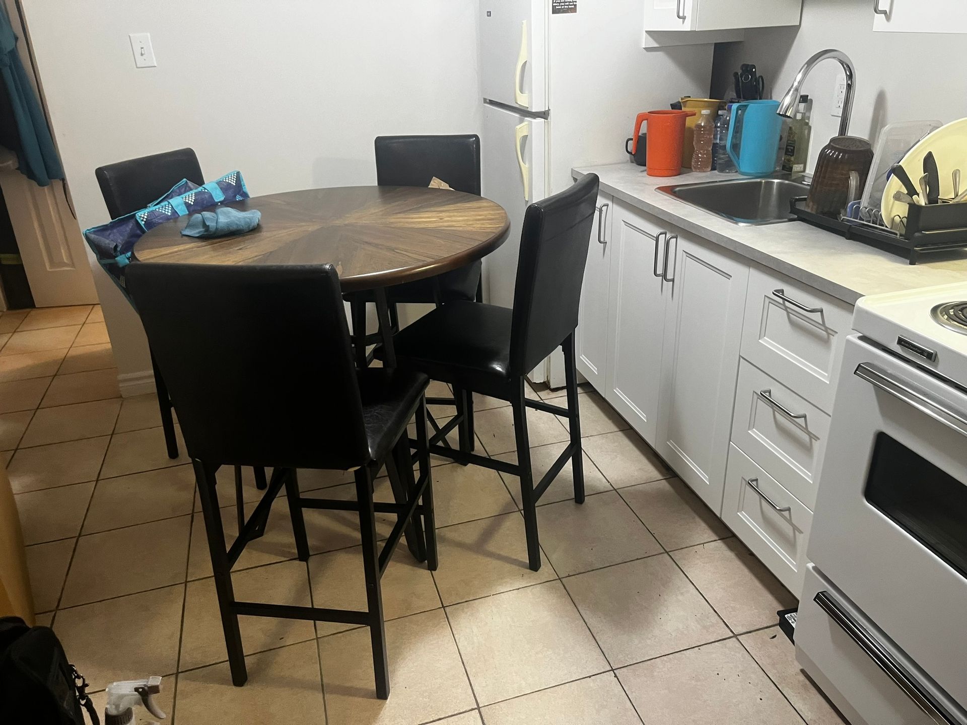 A kitchen with a table and chairs in it
