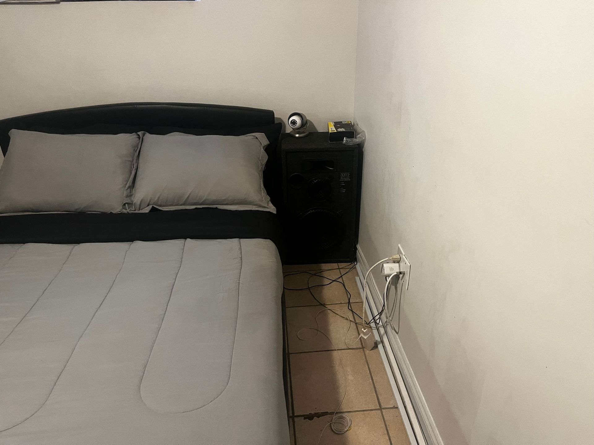 A bedroom with a bed and a nightstand.