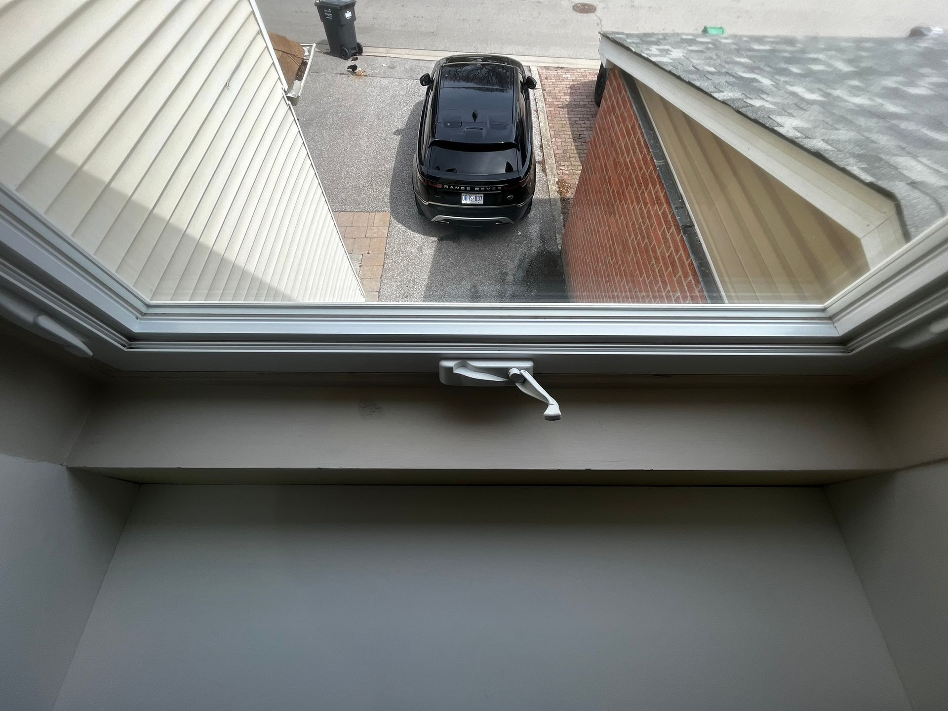 A car is parked in a driveway next to a house