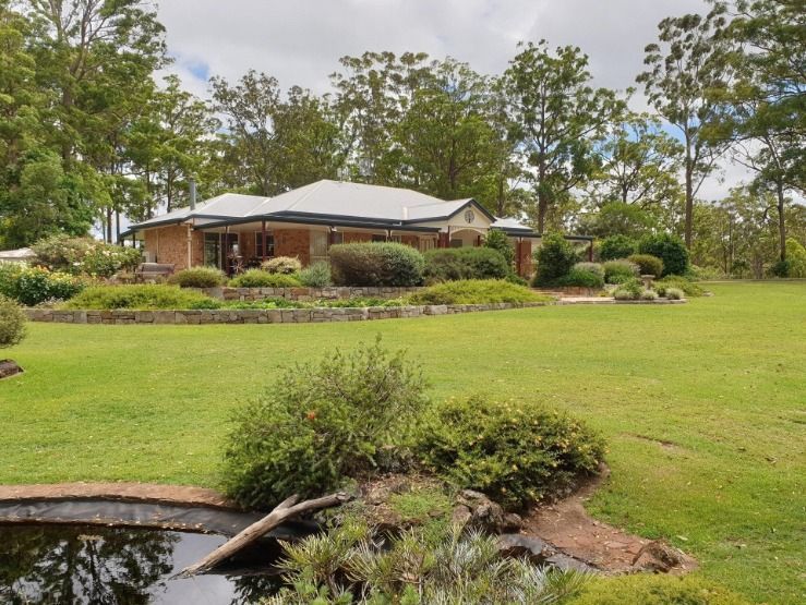 Large House With a Pond in Front of It — Australian Sandstone Products In Helidon, QLD
