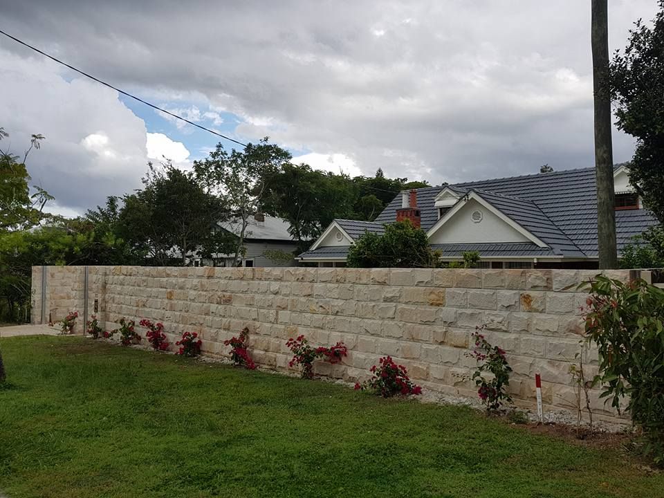 Stone Wall in Front of a House, With Roses Planted Along It — Australian Sandstone Products In Helidon, QLD