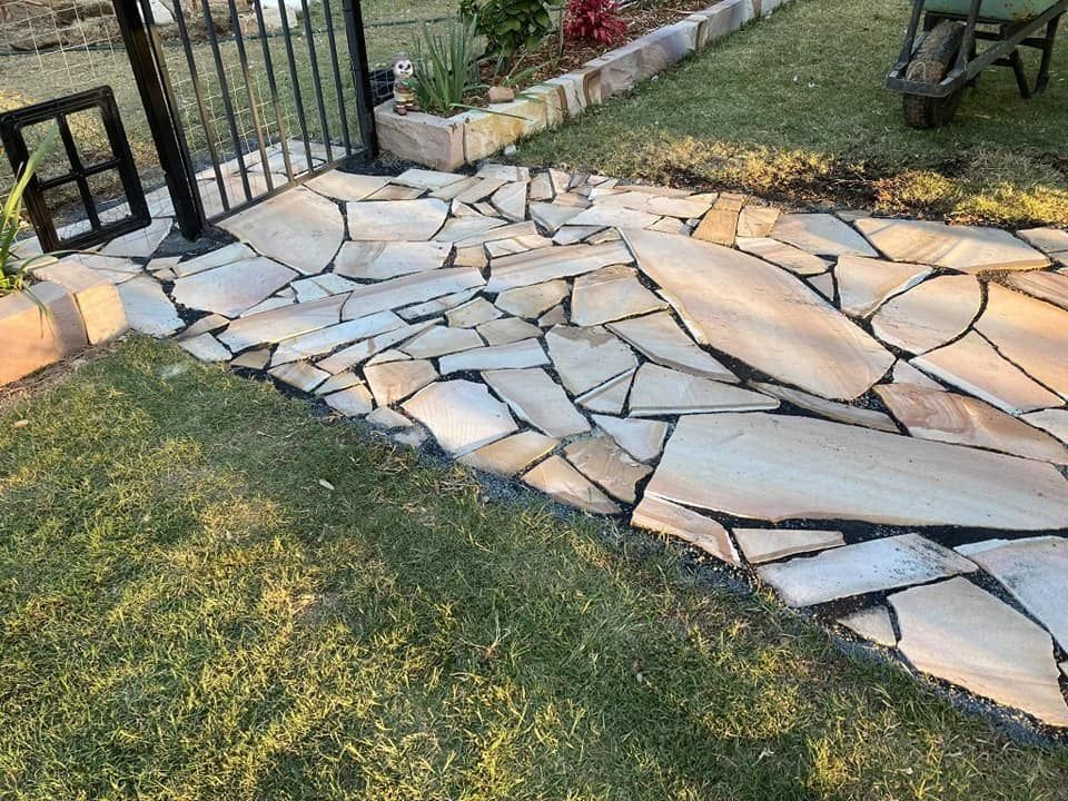 Flagstone Pathway Next to a Lawn and Fence — Australian Sandstone Products In Gatton, QLD