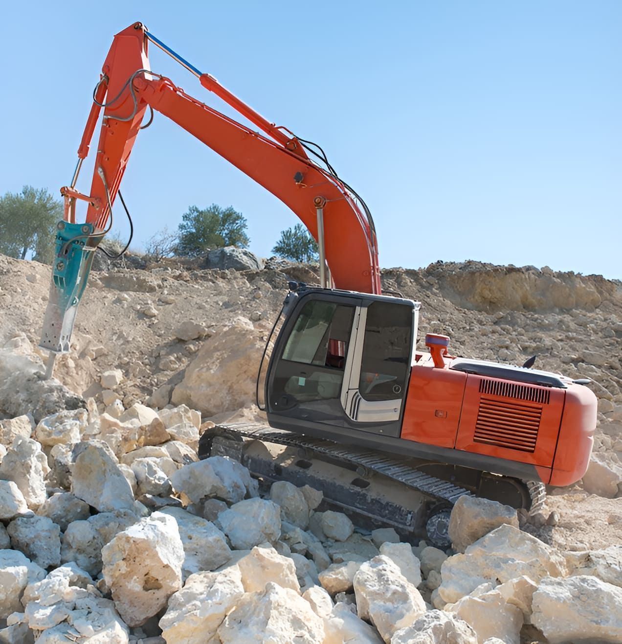 An Orange Excavator Is Working On A Pile Of Rocks — Australian Sandstone Products In Helidon, QLD