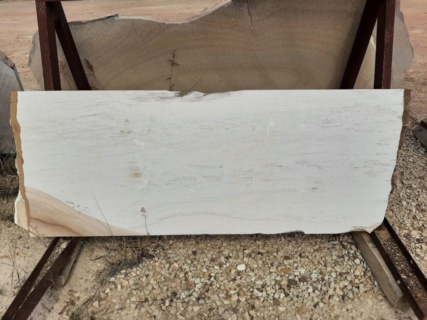 Large Piece of Wood is Sitting on Top of a Pile of Gravel — Australian Sandstone Products In Byron Bay, QLD