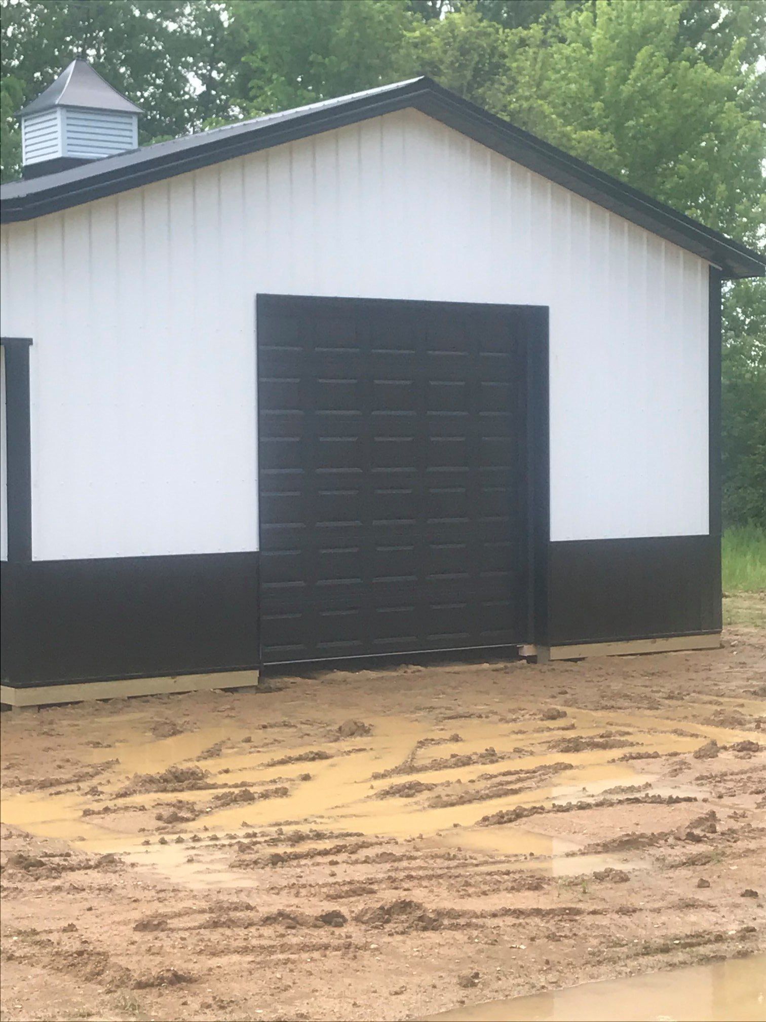 A white and black building with a black garage door