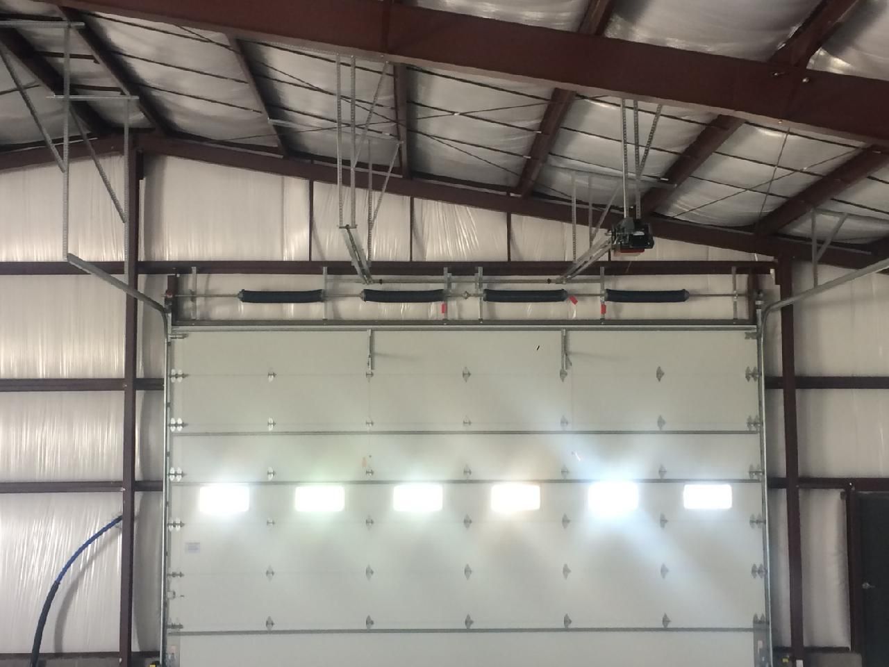 A white garage door is open in a building
