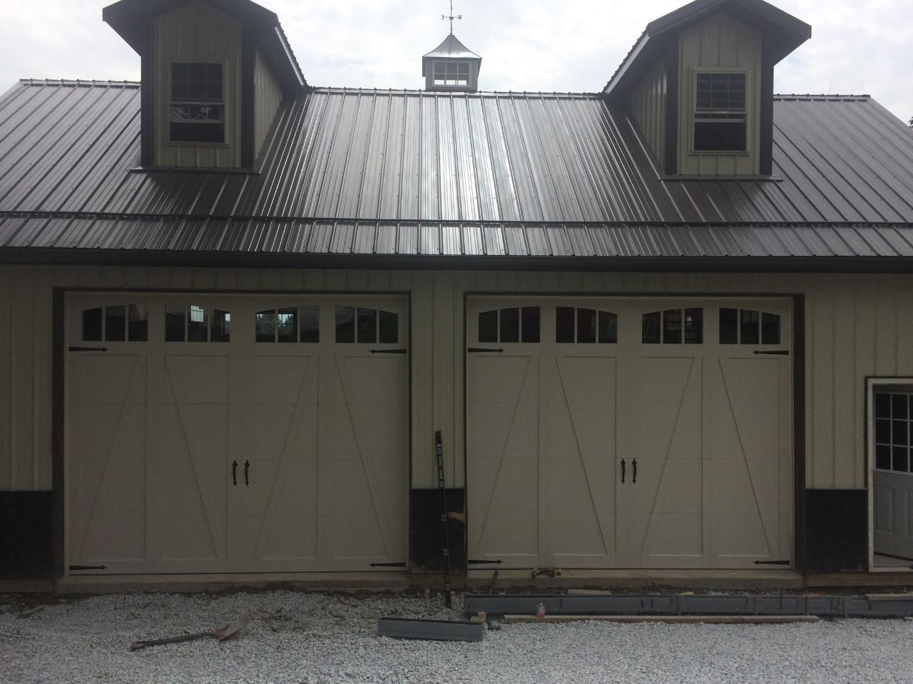 A garage with a brown roof and white doors