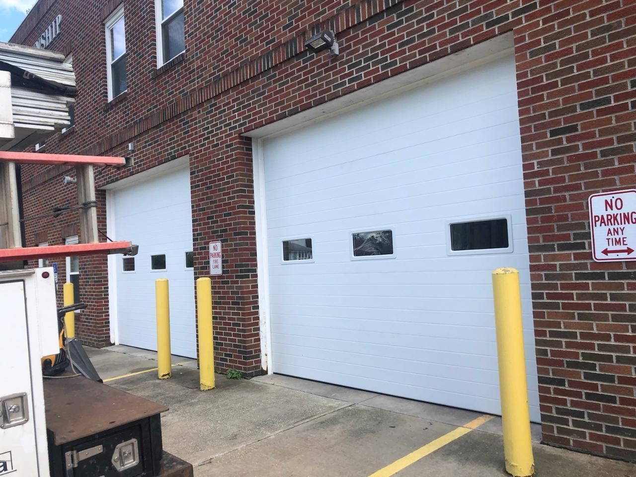 A white truck is parked in front of a brick building
