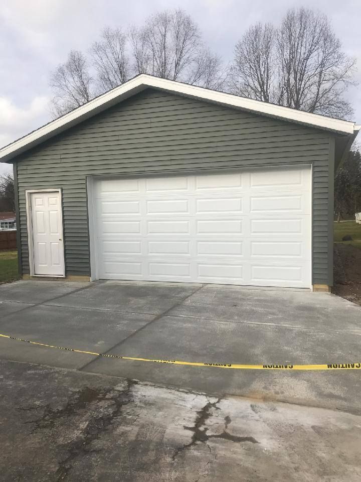 A garage with a white garage door and a concrete driveway.