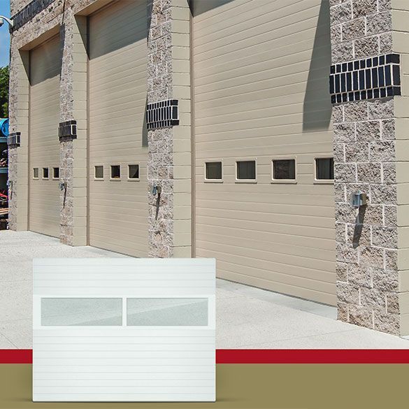 A white garage door is sitting in front of a building