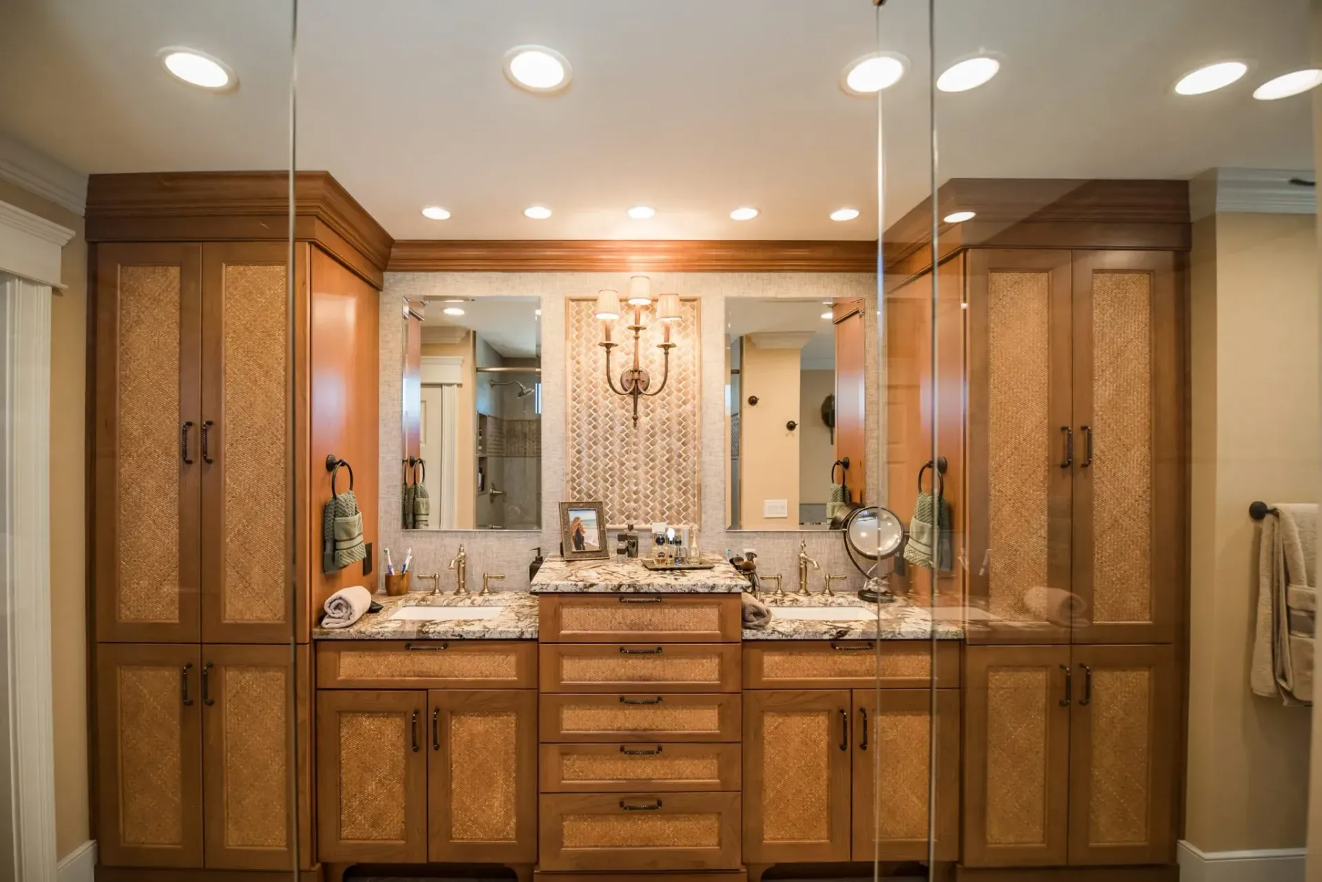 A bathroom with two sinks , two mirrors and a walk in shower.
